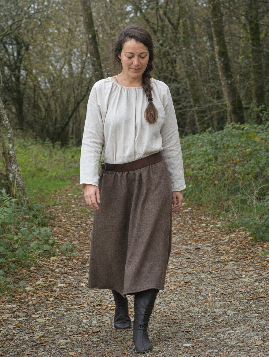 Woman in a white blouse, brown skirt and mid-calf lace-up boots on a woodland path