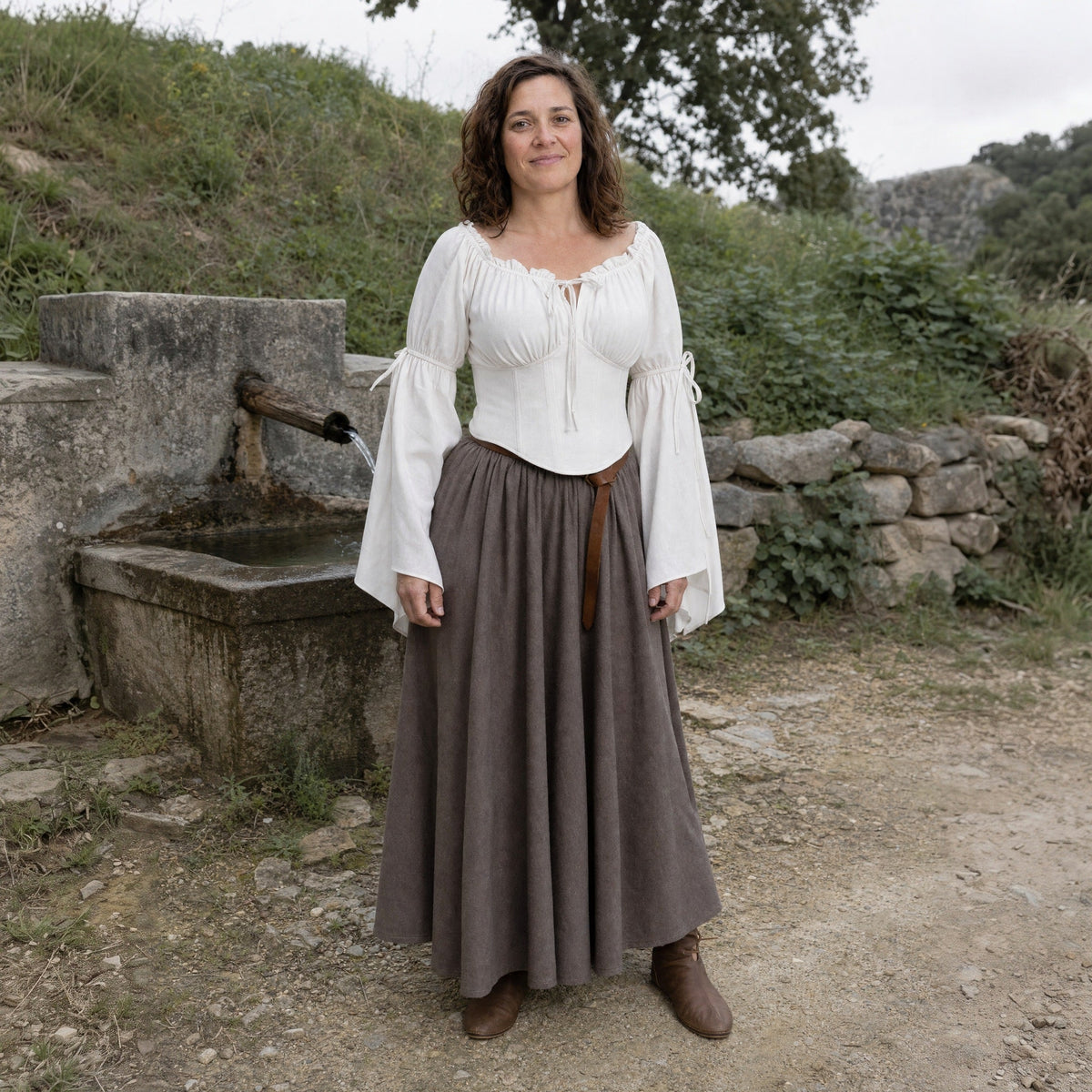A woman in the Renaissance Lady look outdoors: white flared-sleeve blouse and long skirt