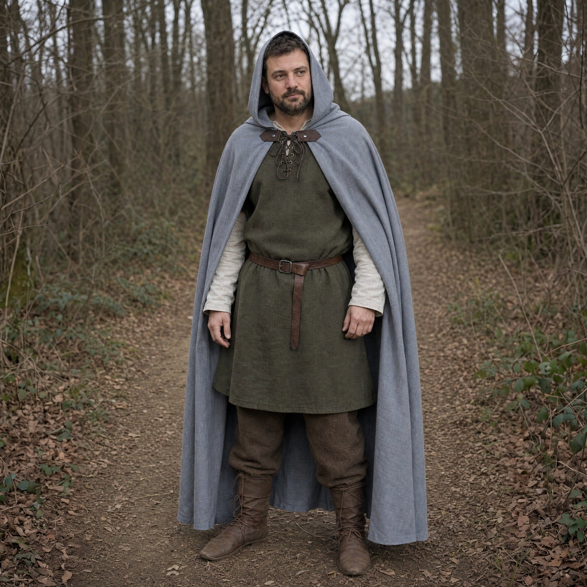 A man in the Forest Ranger look outdoors: grey hooded cloak over a green tunic