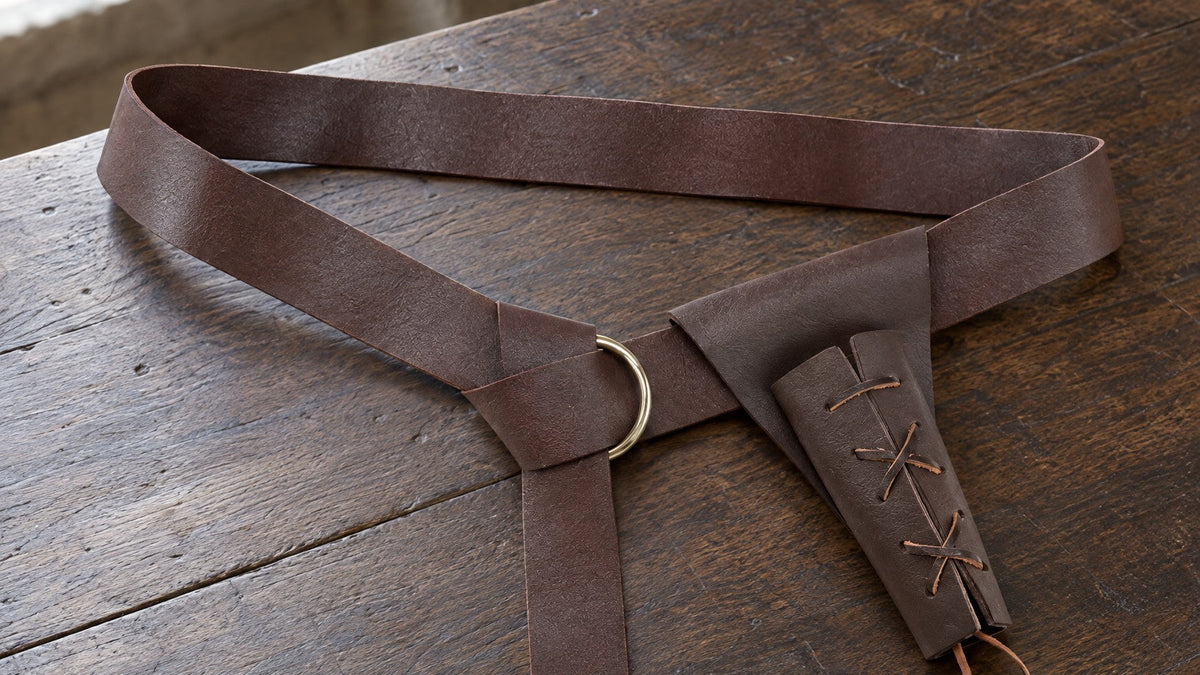 Brown knight belt with sword frog on a wooden table by a window
