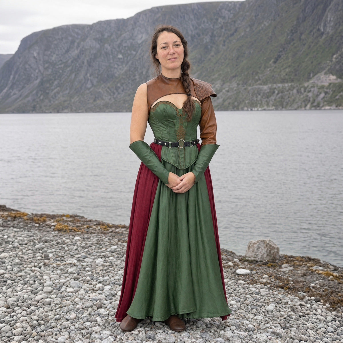 A woman in the Shieldmaiden look outdoors: green satin gown with laced bodice