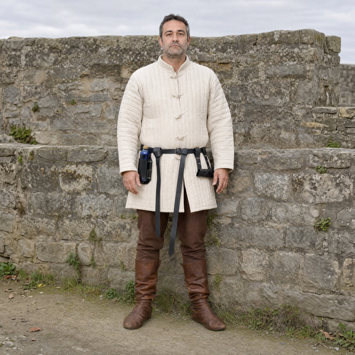 Black belt with bottle holder and double frog worn outdoors, full-length front view