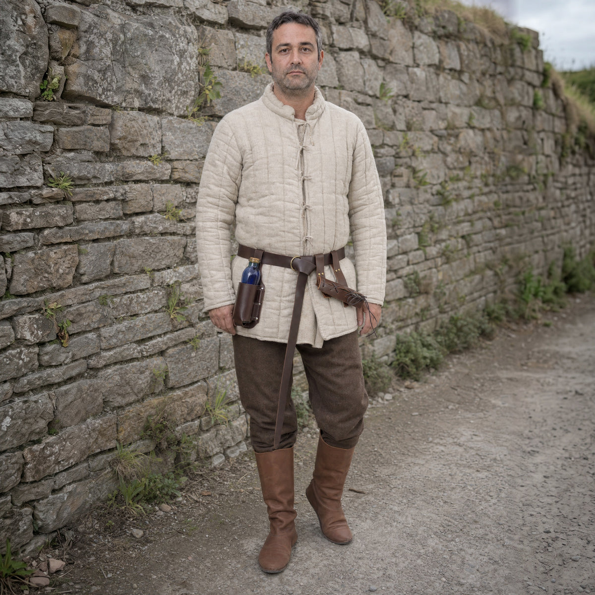 Brown belt with bottle holder and double frog worn outdoors, full-length front view