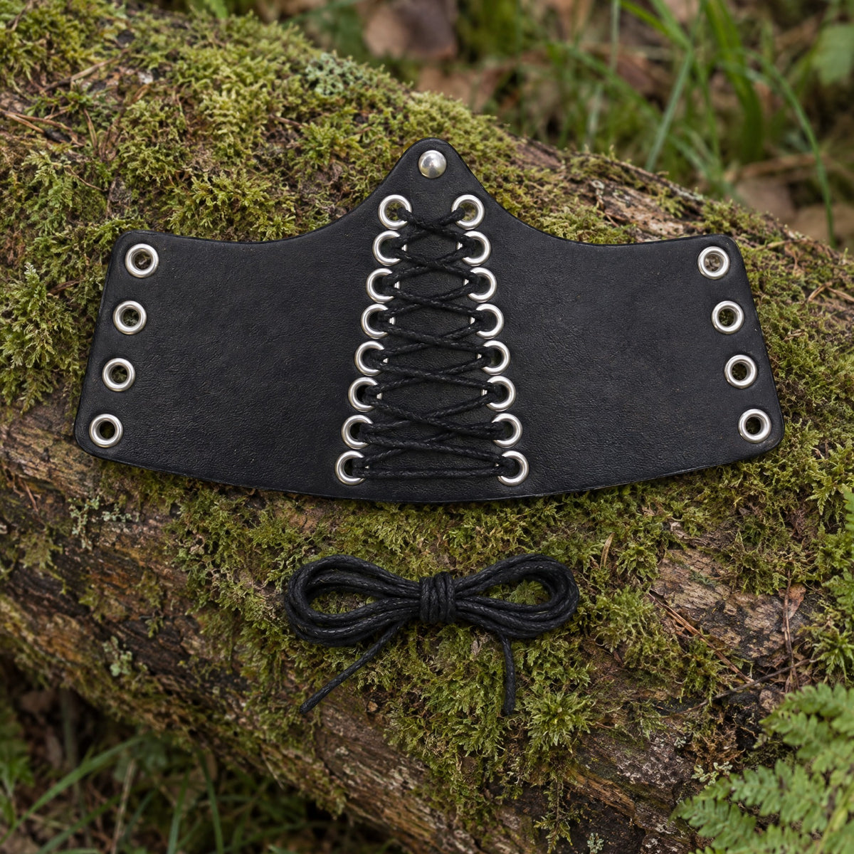 Black centre-laced wrist cuff on a rustic surface