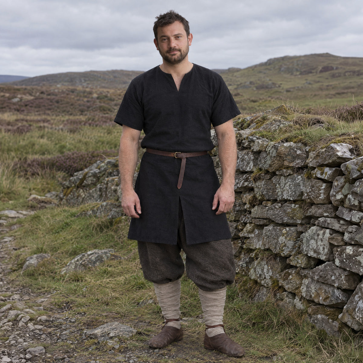 Black cotton Viking tunic worn by a man outdoors, full-length front view