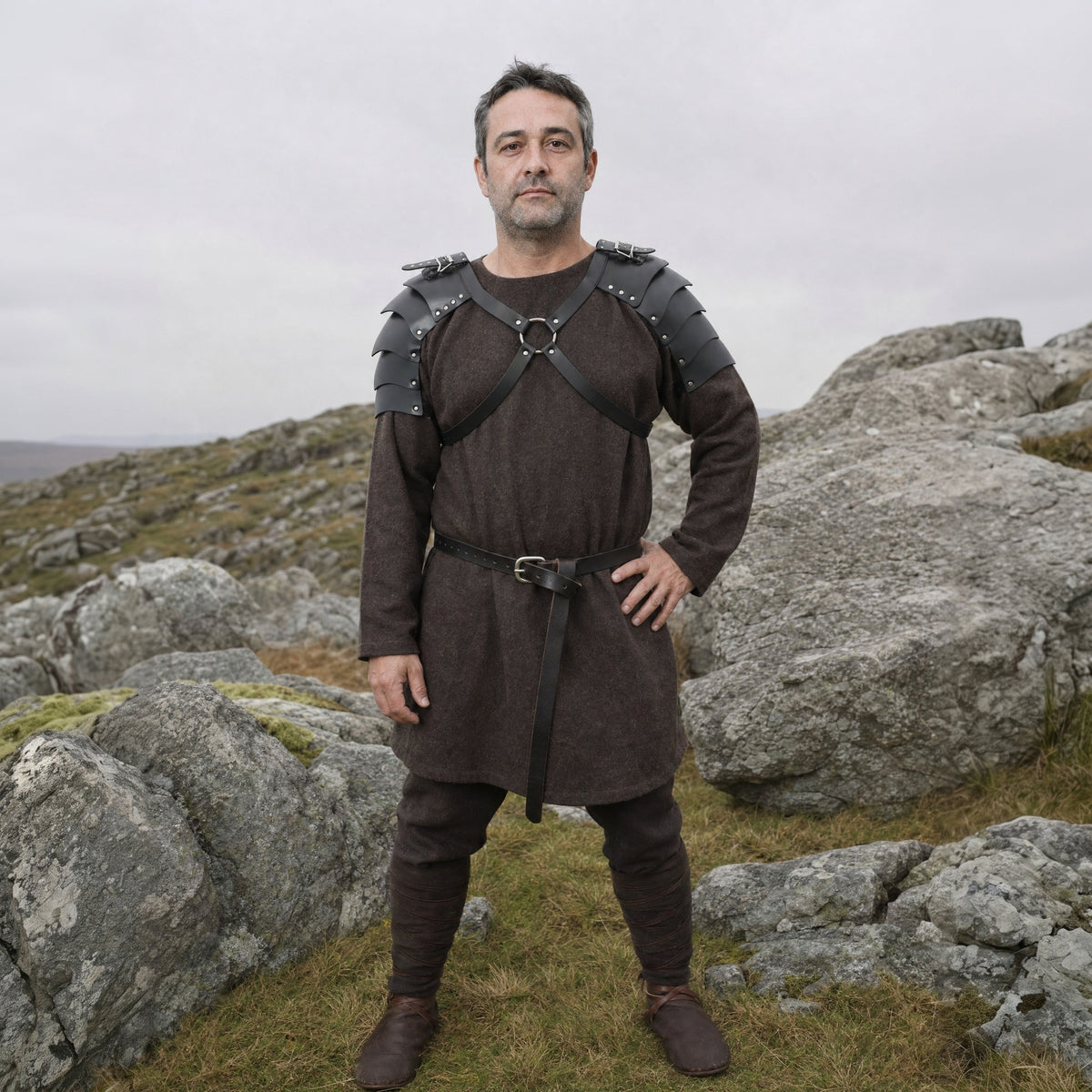 Black faux leather double shoulder armour worn by a man outdoors, full-length front view