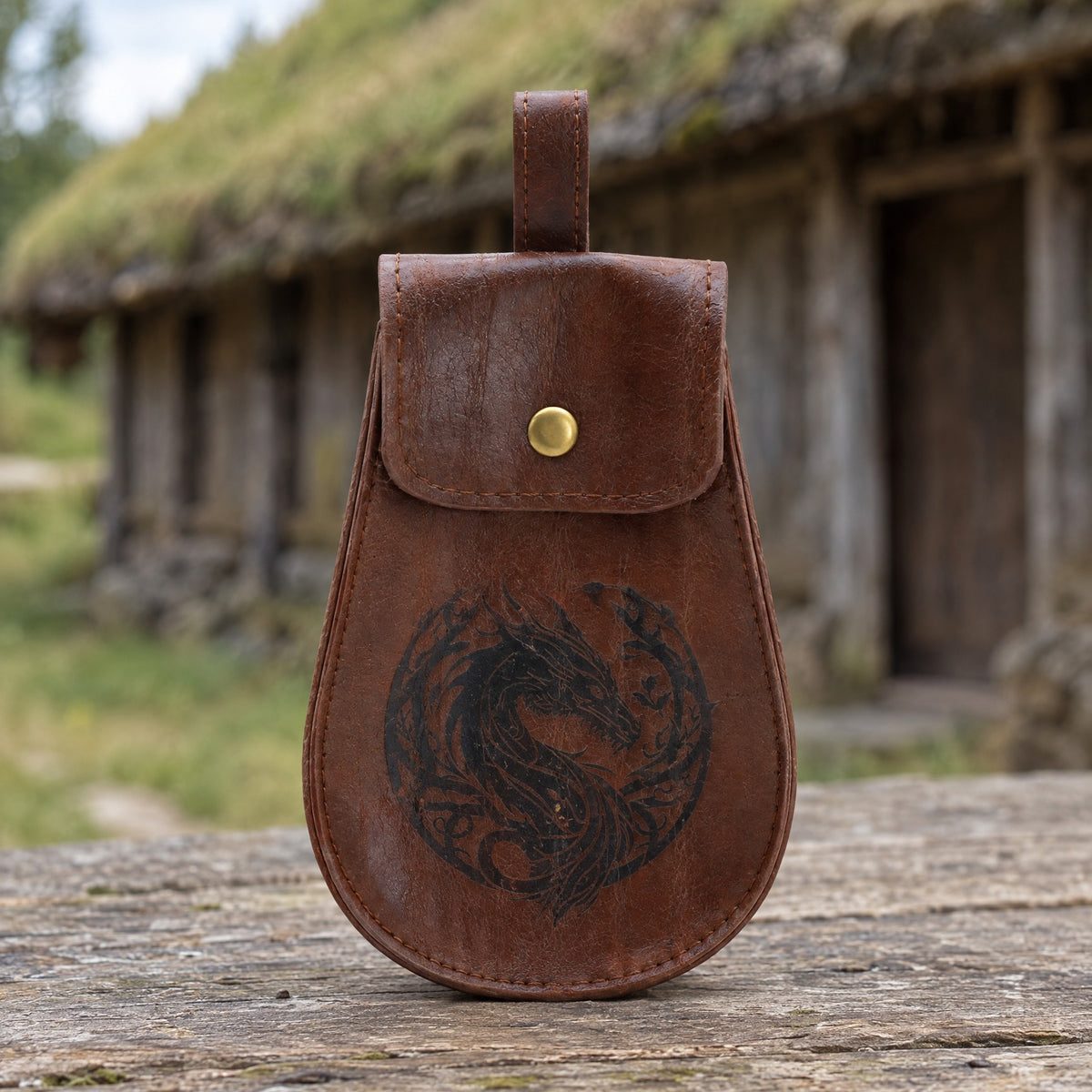 Brown dragon emblem belt pouch on a rustic surface