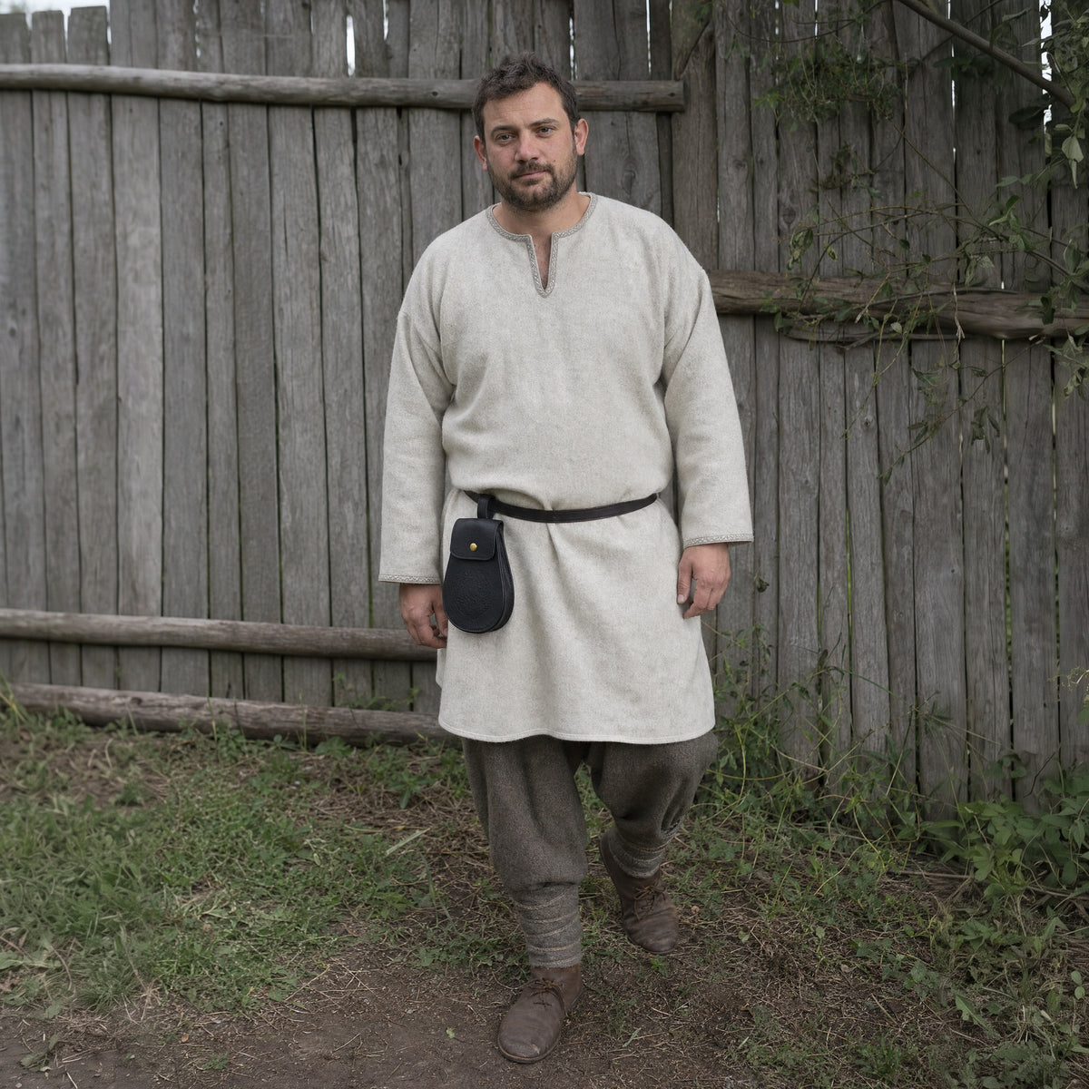 Black dragon emblem belt pouch worn outdoors, full-length front view