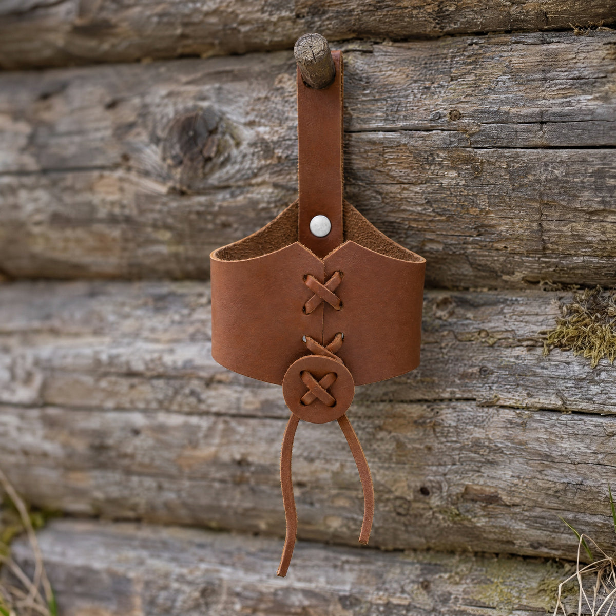 Brown laced drinking horn holder on a rustic surface