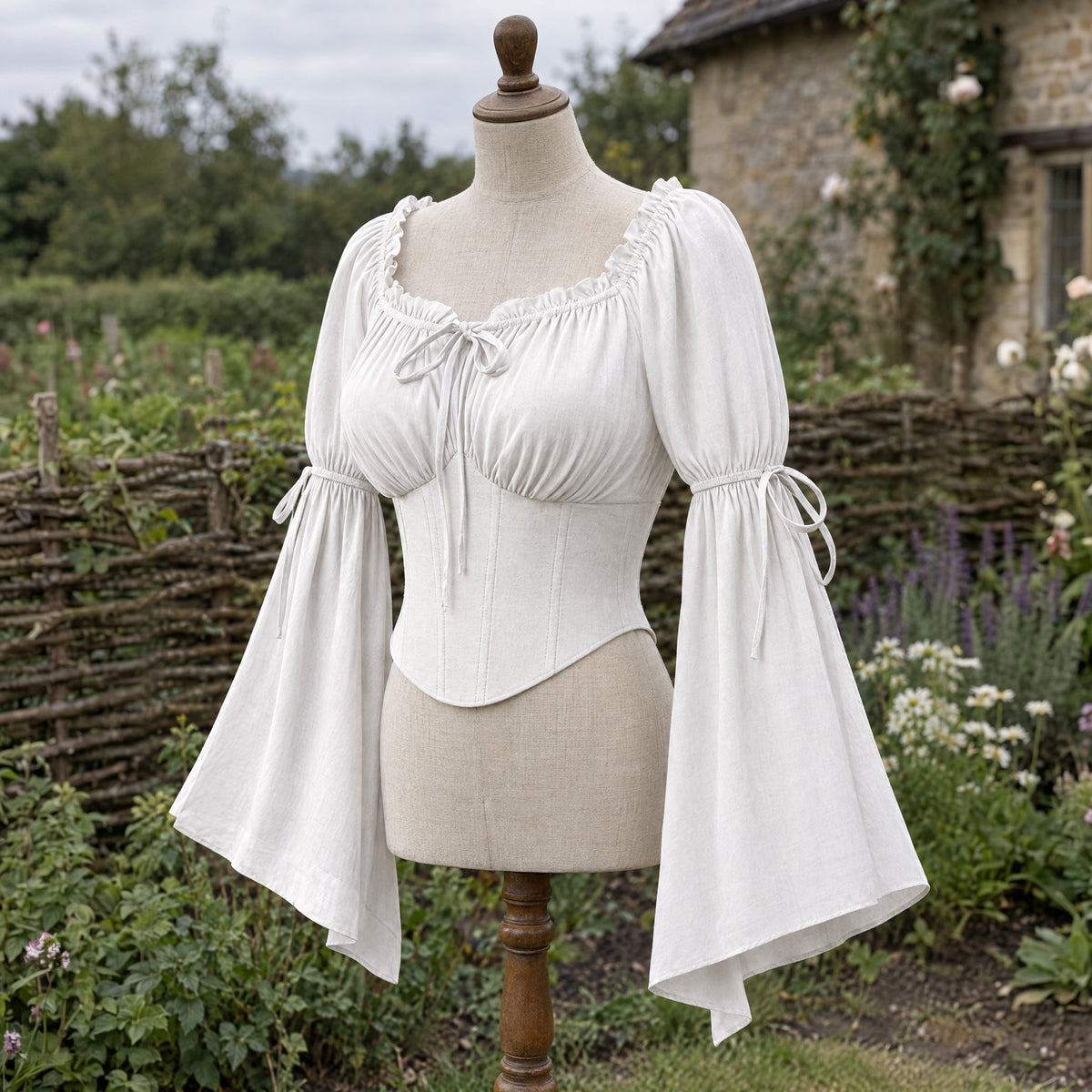 White flared-sleeve renaissance blouse on a dress form outdoors