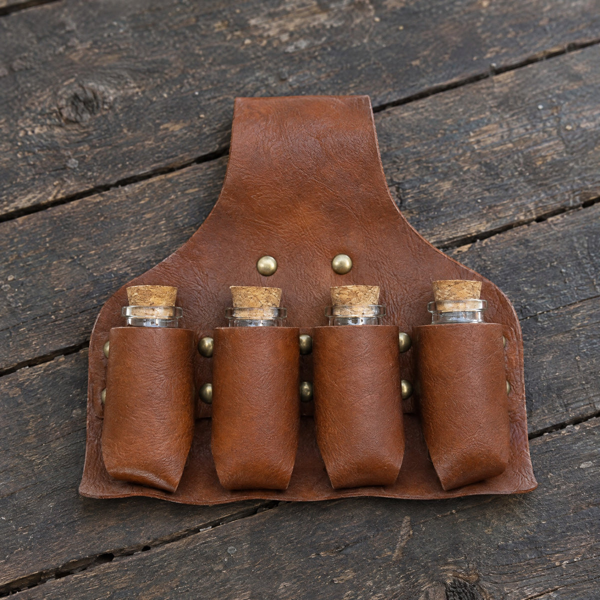 Brown four-vial potion belt holder on a rustic surface