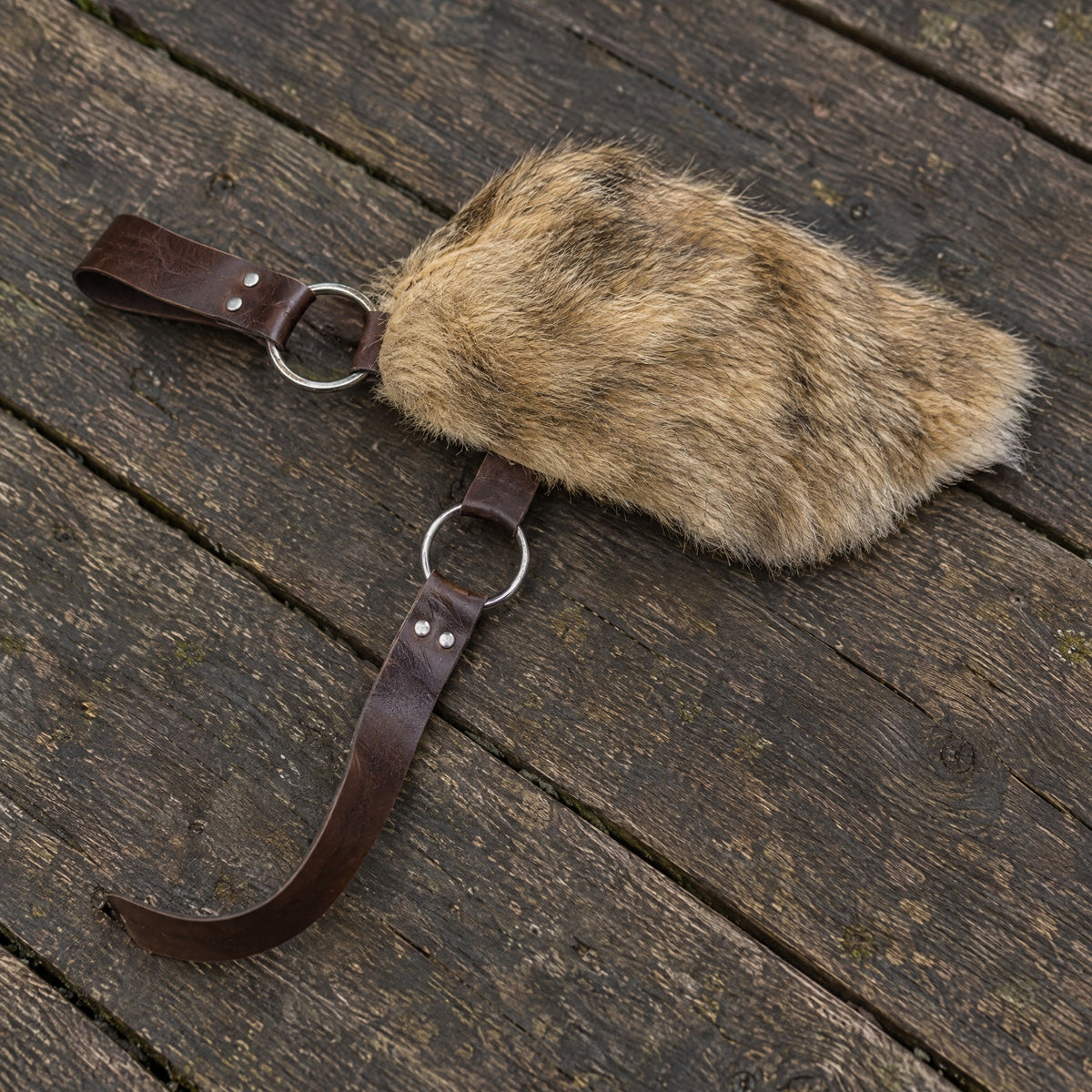 Brown fur-look single pauldron on a rustic surface
