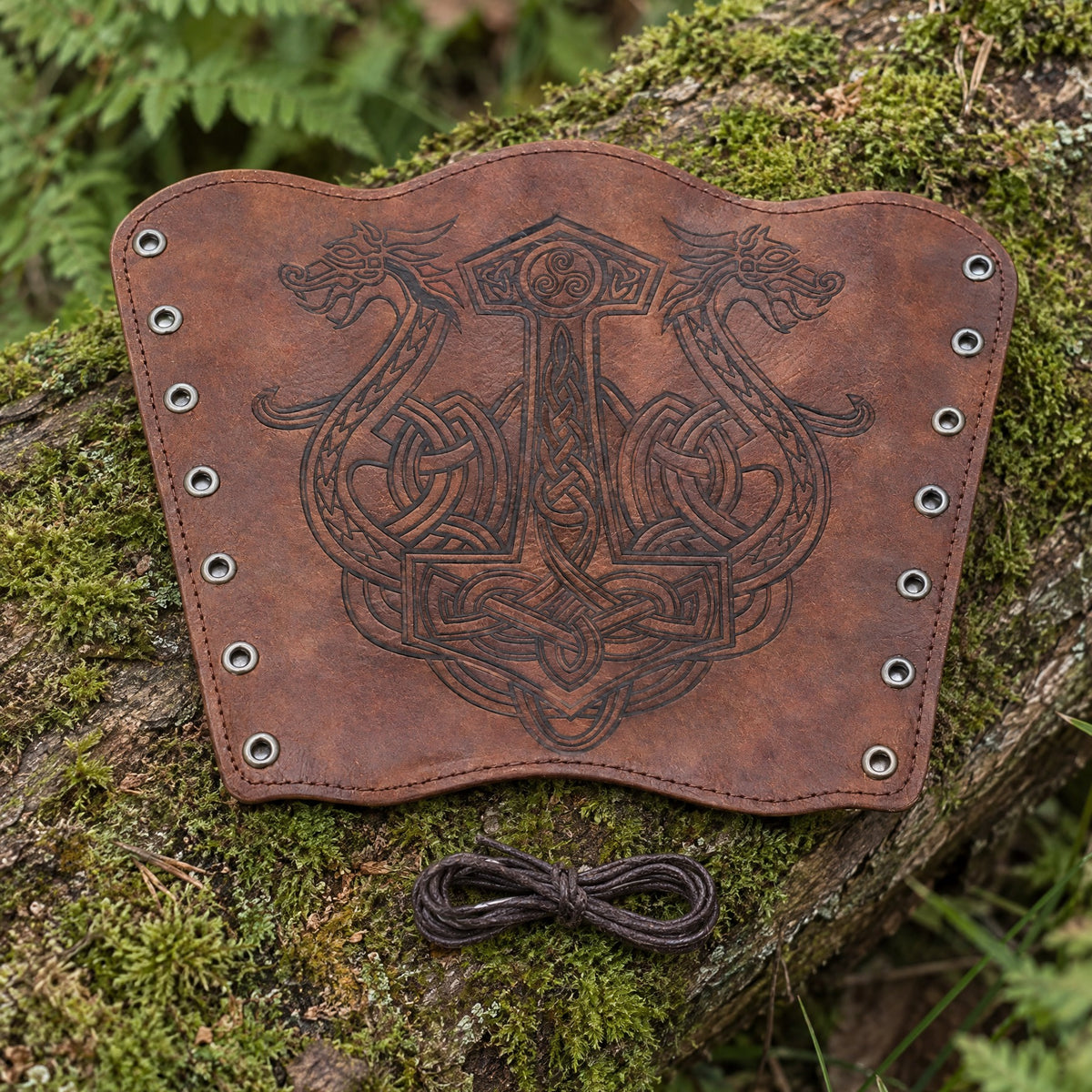 Red-brown hammer and dragons bracer on a rustic surface