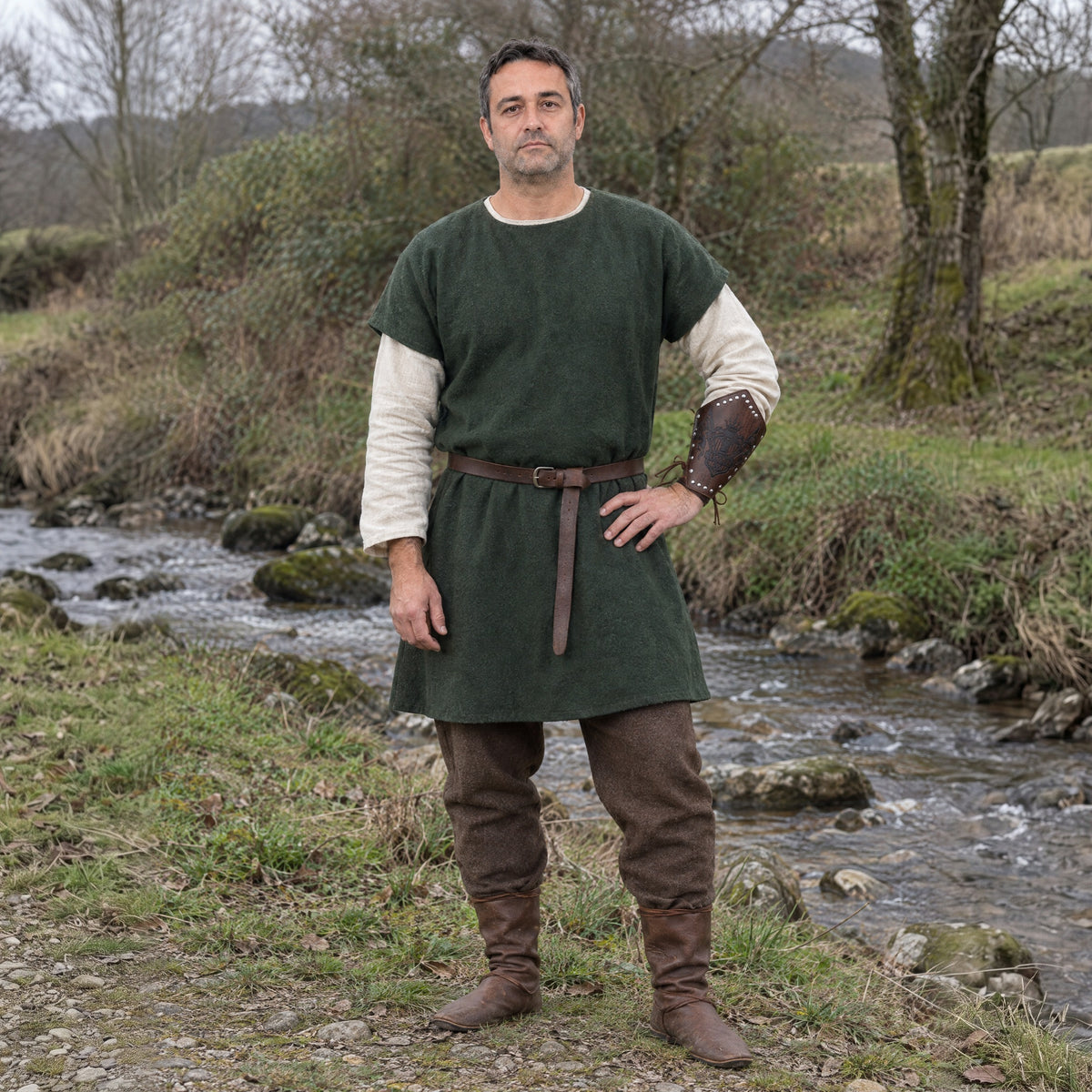 Brown heraldic banner bracer worn on the forearm outdoors, full-length front view