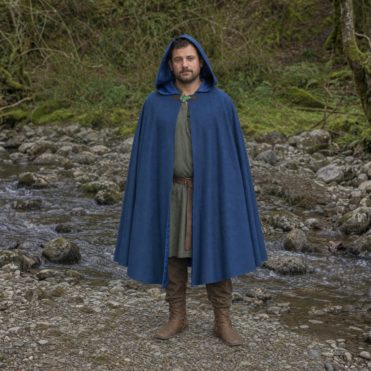 Blue hooded cloak with leaf brooch worn outdoors, full-length front view