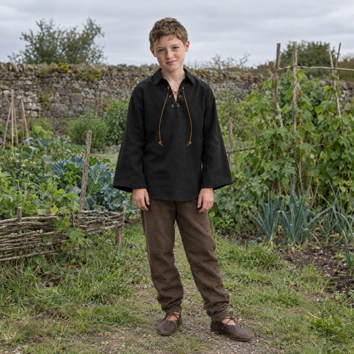 Black kids' lace-up renaissance shirt worn by a child outdoors, full-length front view