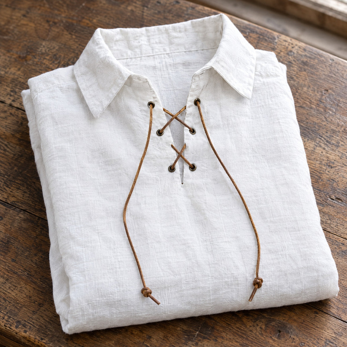 White kids' lace-up renaissance shirt on a rustic surface