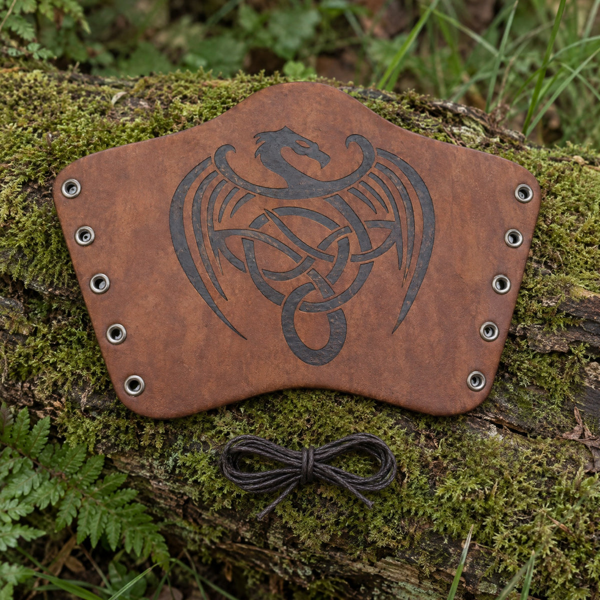 Brown knotwork dragon bracer on a rustic surface