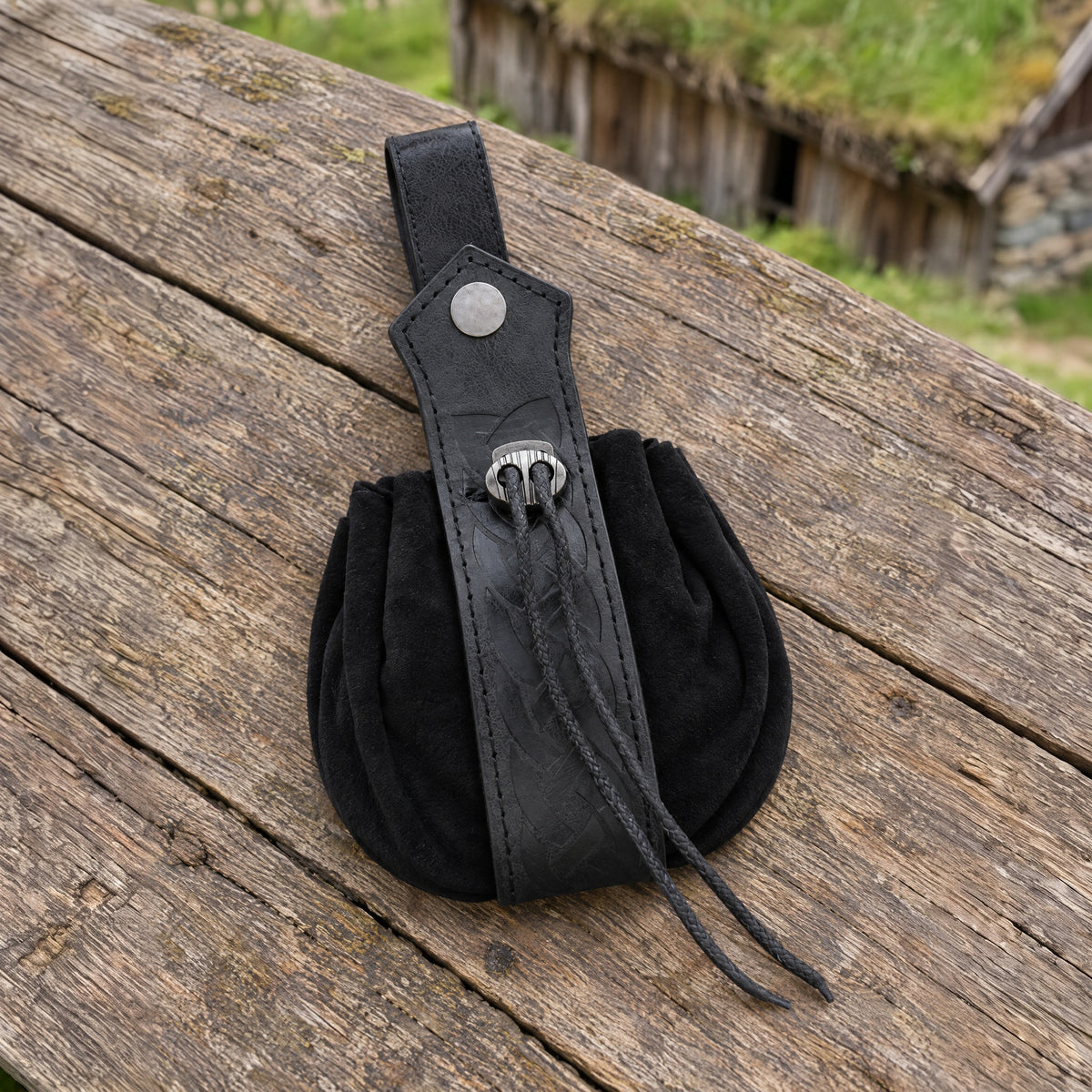 Black knotwork drawstring belt pouch on a rustic surface