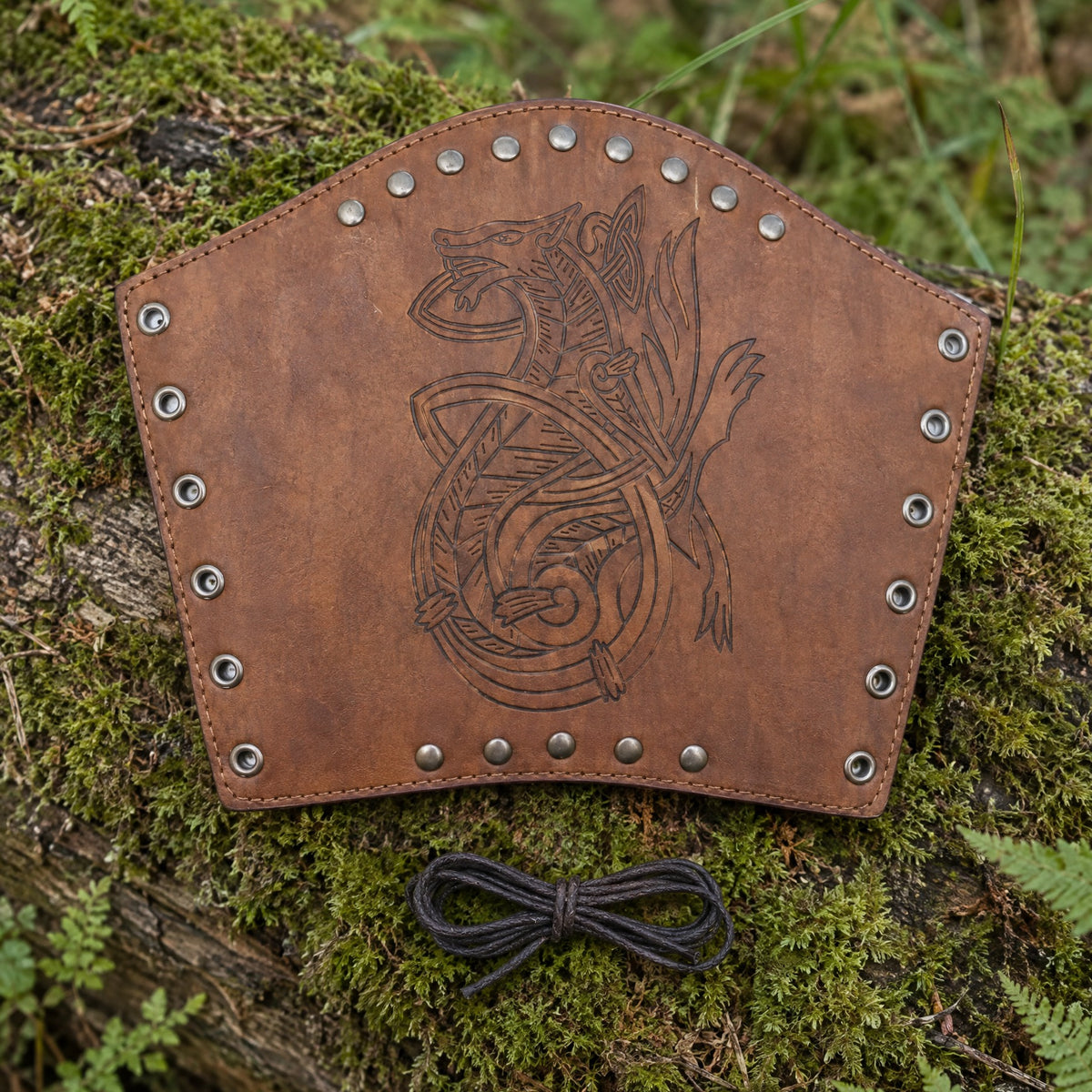 Brown knotwork wolf bracer on a rustic surface
