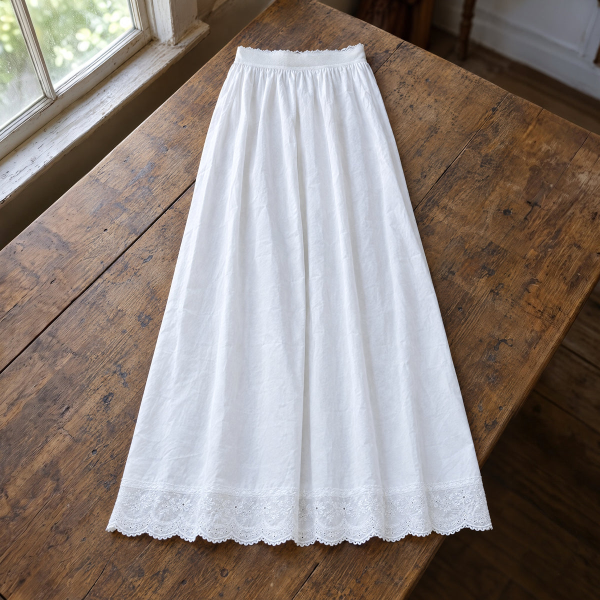 White lace-hem cotton petticoat on a rustic surface