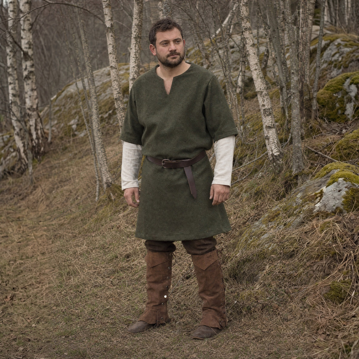 Brown lace-up studded gaiters worn over boots outdoors, full-length front view
