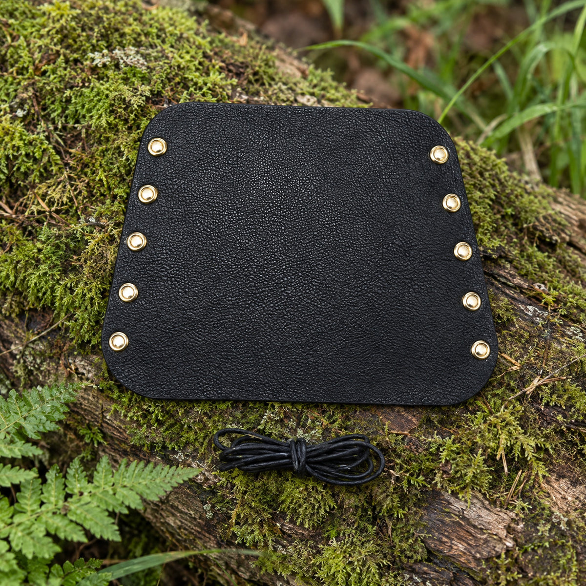 Black laced wrist guard on a rustic surface