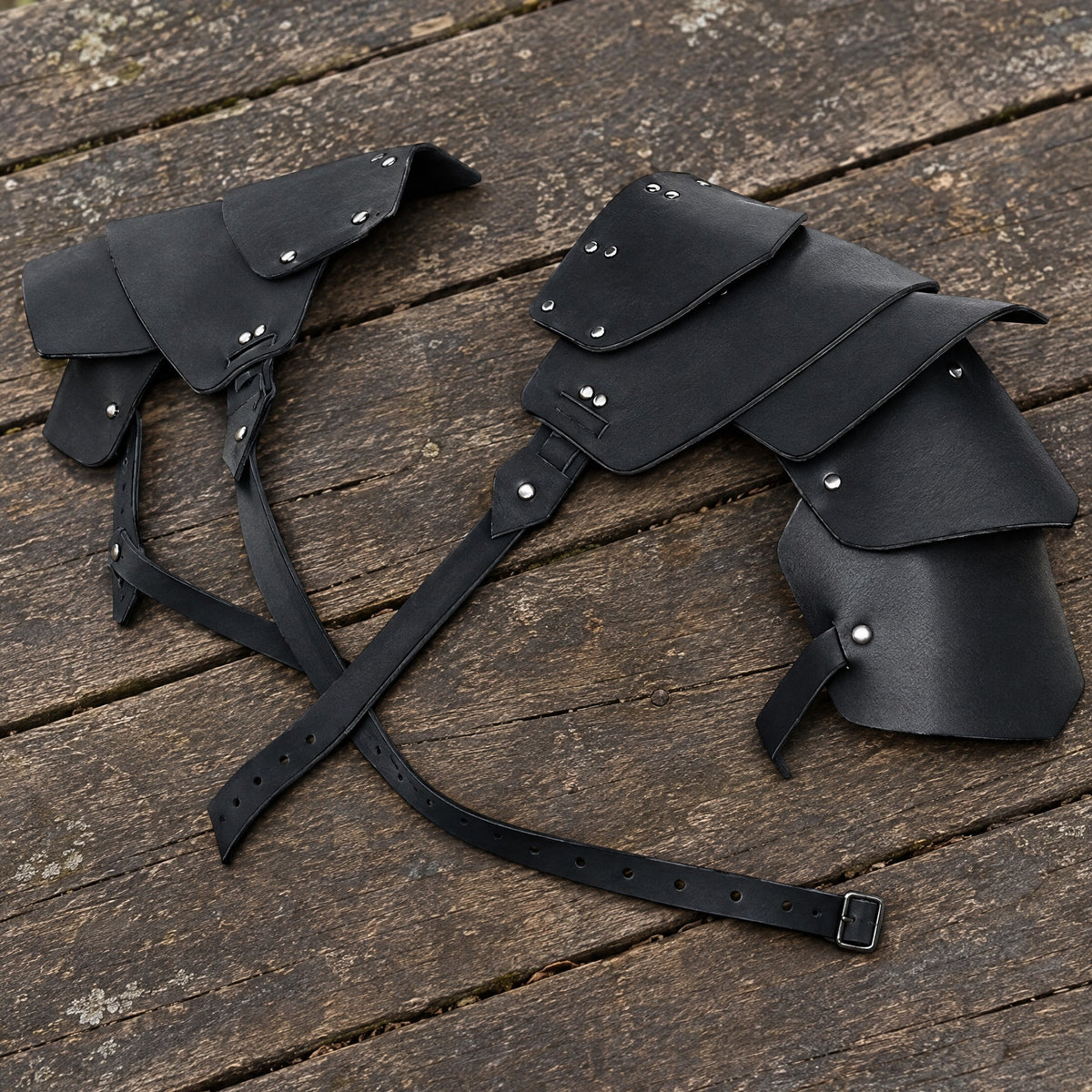 Black layered double pauldrons on a rustic surface