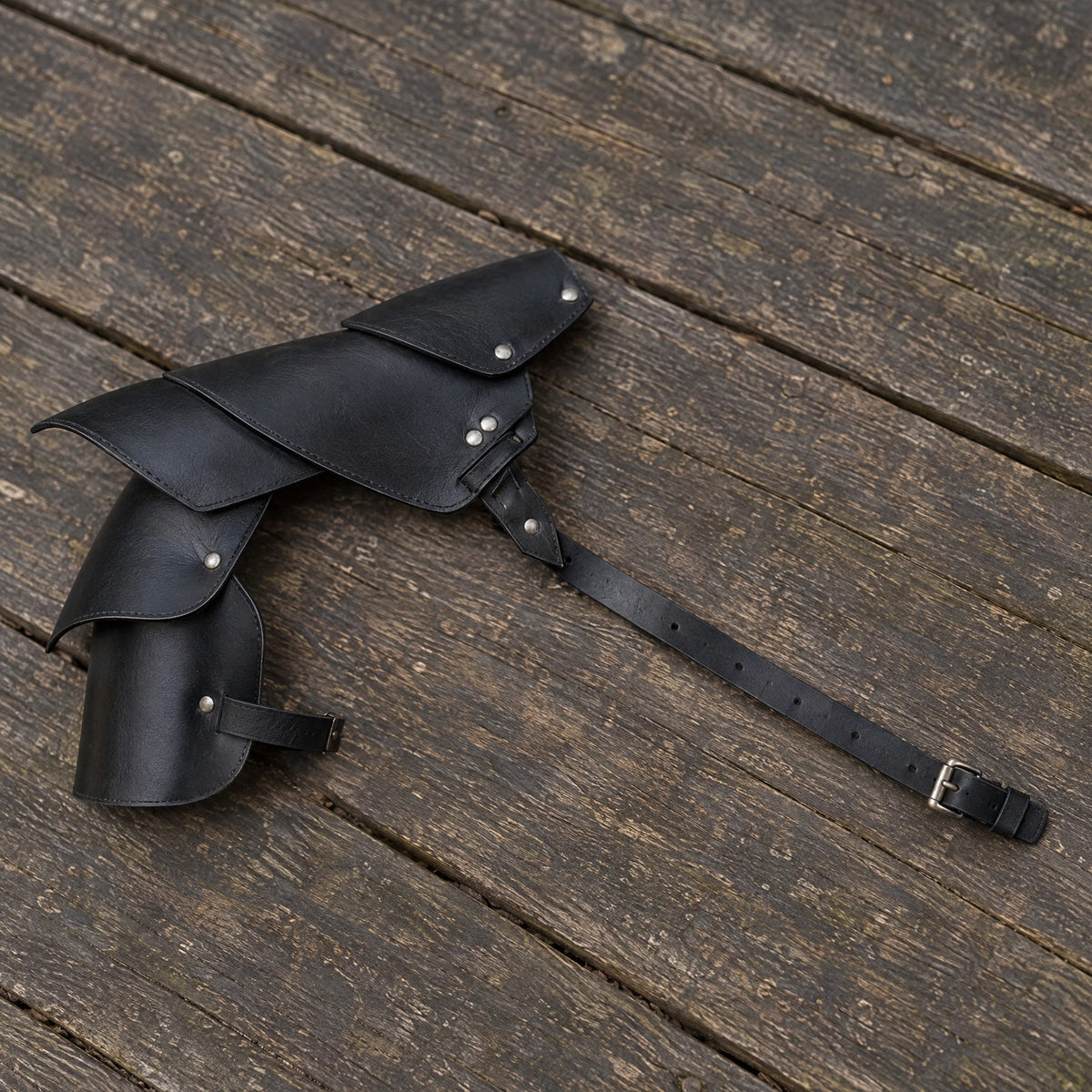 Black layered single pauldron on a rustic surface