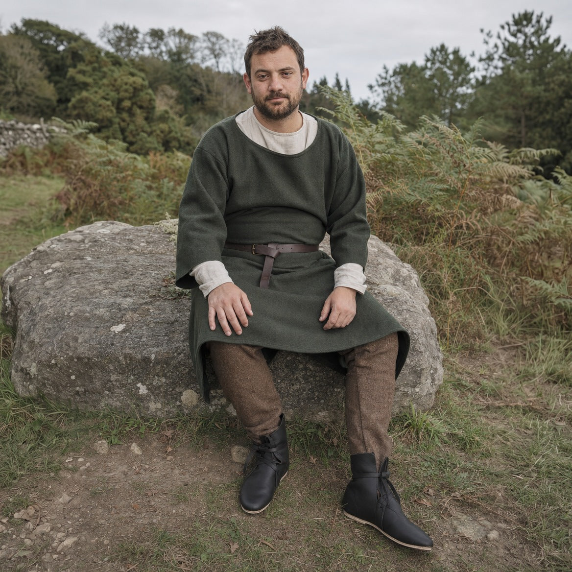 Low faux leather boots styled with plain trousers, leg wraps and a tunic