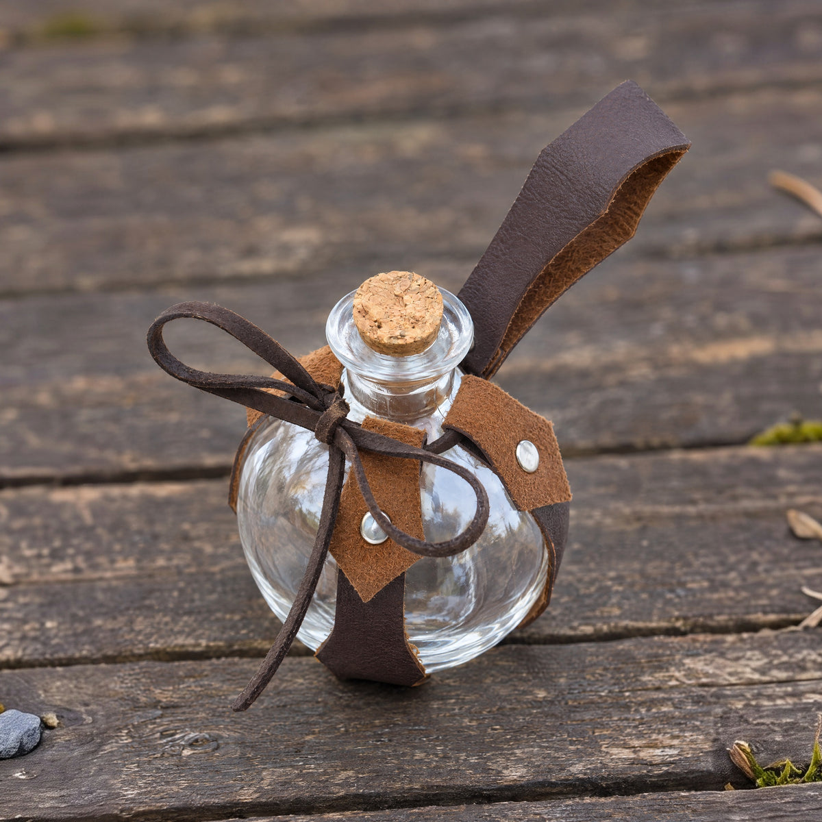 Brown maple leaf potion bottle with belt holder on a rustic surface