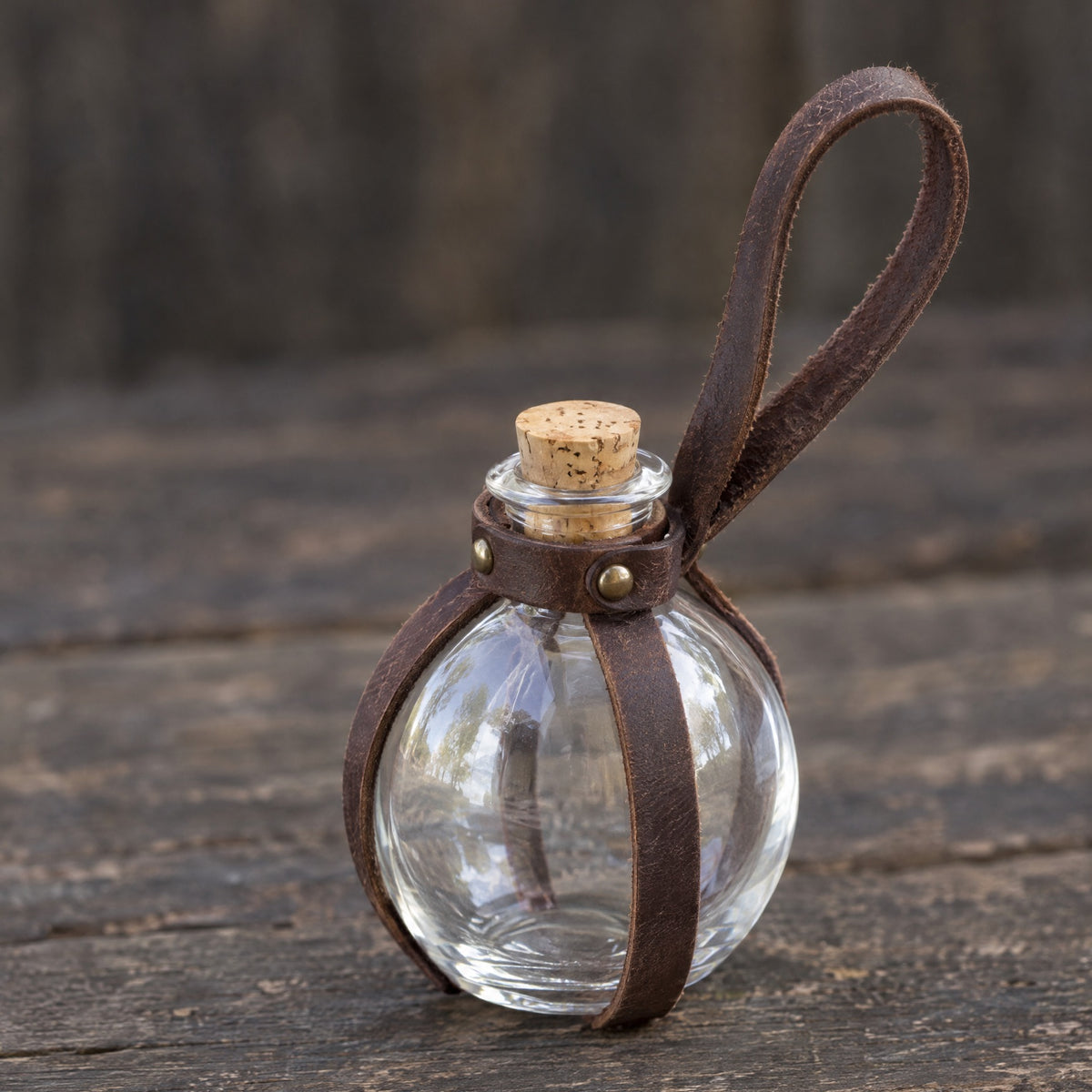Brown round potion bottle with belt holder on a rustic surface
