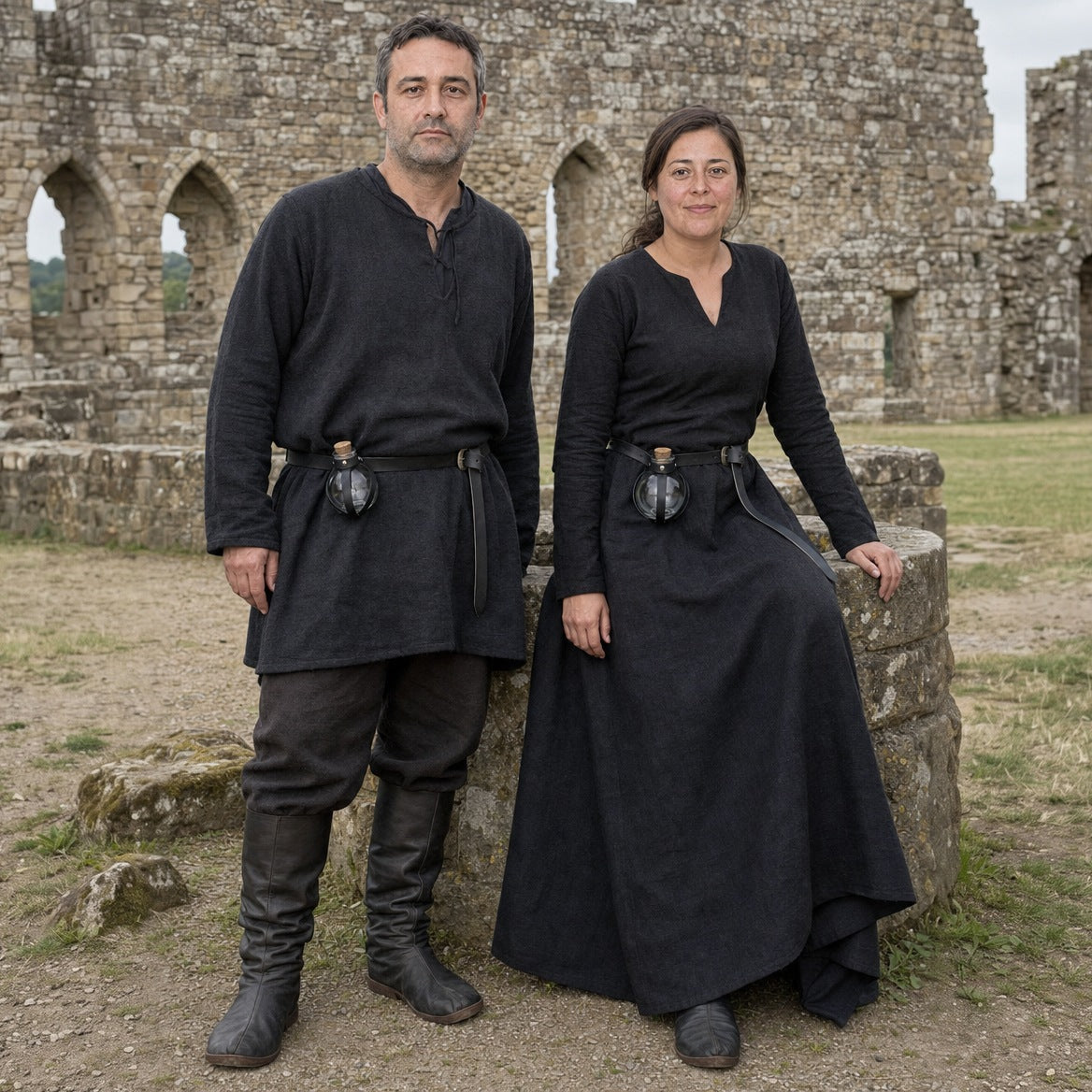 Black round potion bottles with belt holders worn by a man and a woman outdoors