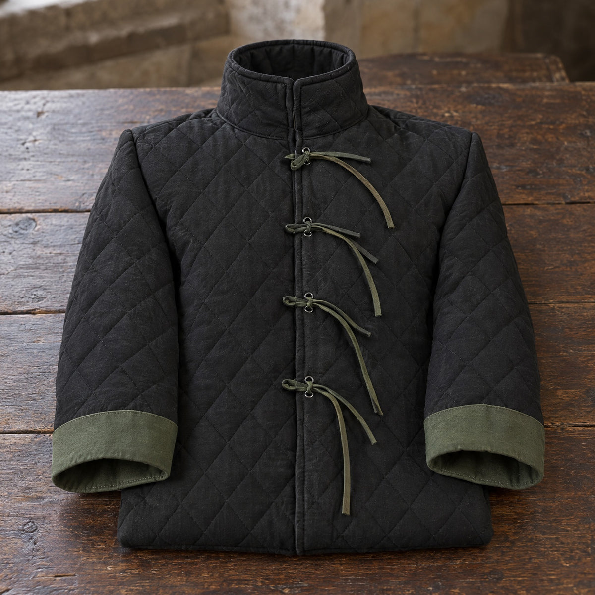 Black quilted padded coat on a rustic surface
