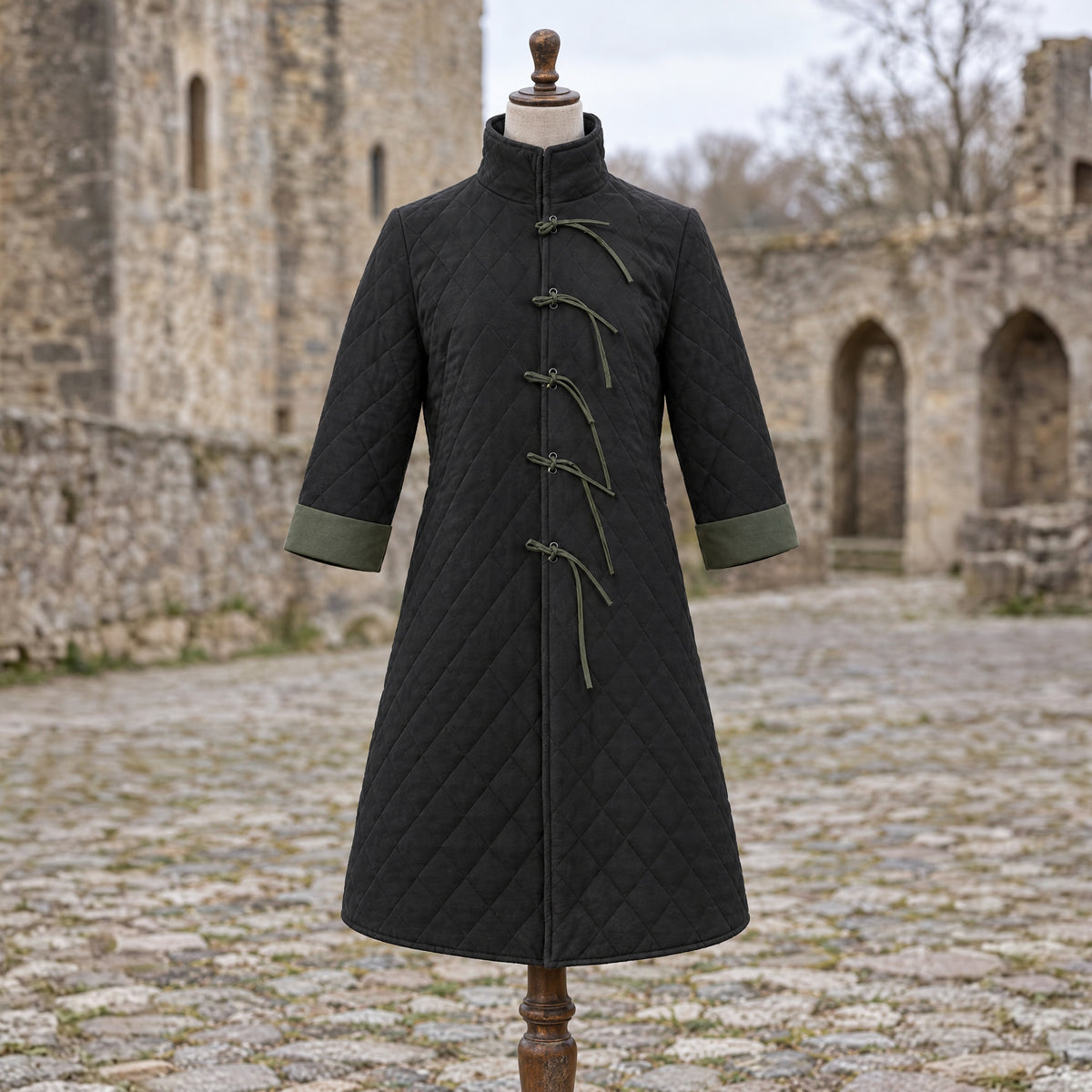 Black quilted padded coat on a dress form outdoors