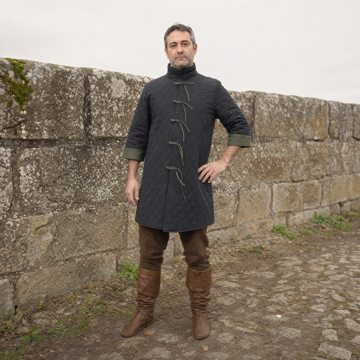 Black quilted padded coat worn by a man outdoors, full-length front view