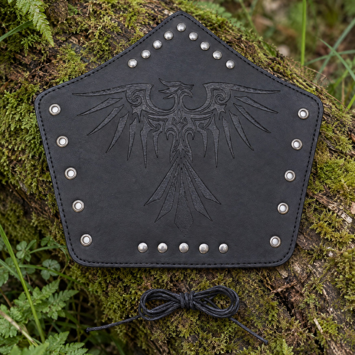 Black raven bracer on a rustic surface