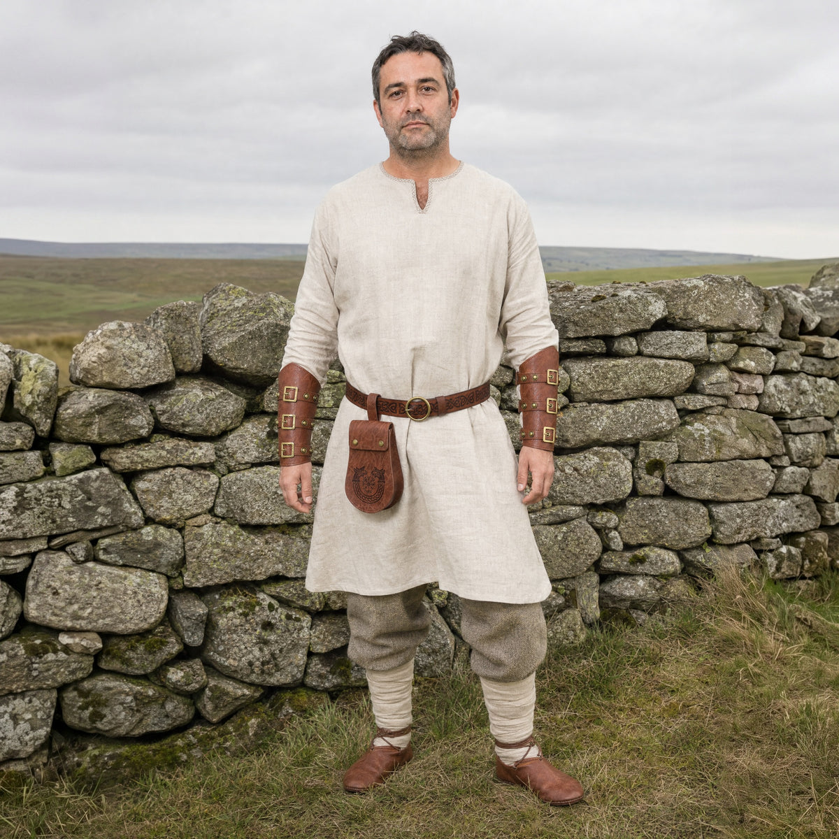 Brown ring belt, pouch and buckled bracers set worn outdoors, full-length front view