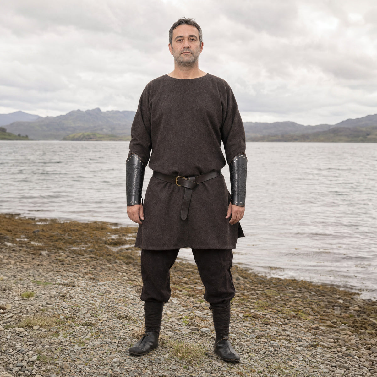 Black riveted World Tree bracers worn outdoors, full-length front view