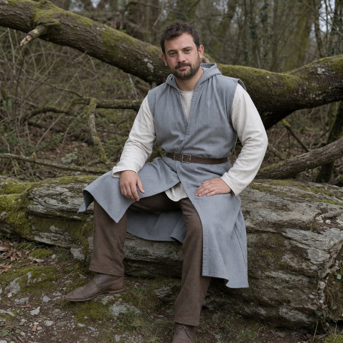 Sleeveless cotton tunic styled over a plain shirt with a belt, trousers and boots