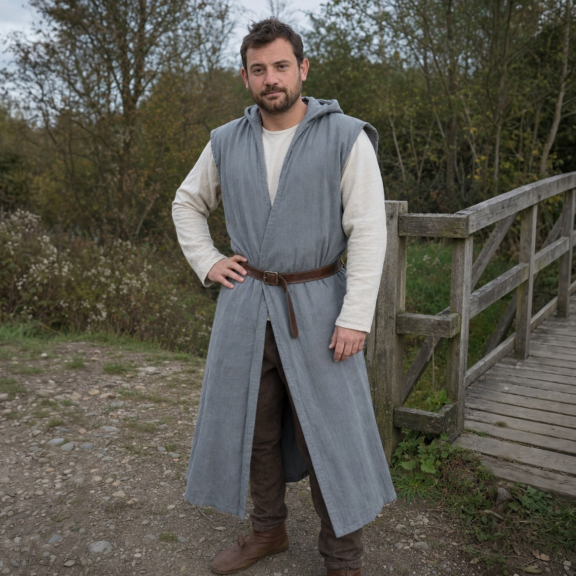Grey sleeveless cotton tunic over a long-sleeve shirt, three-quarter view