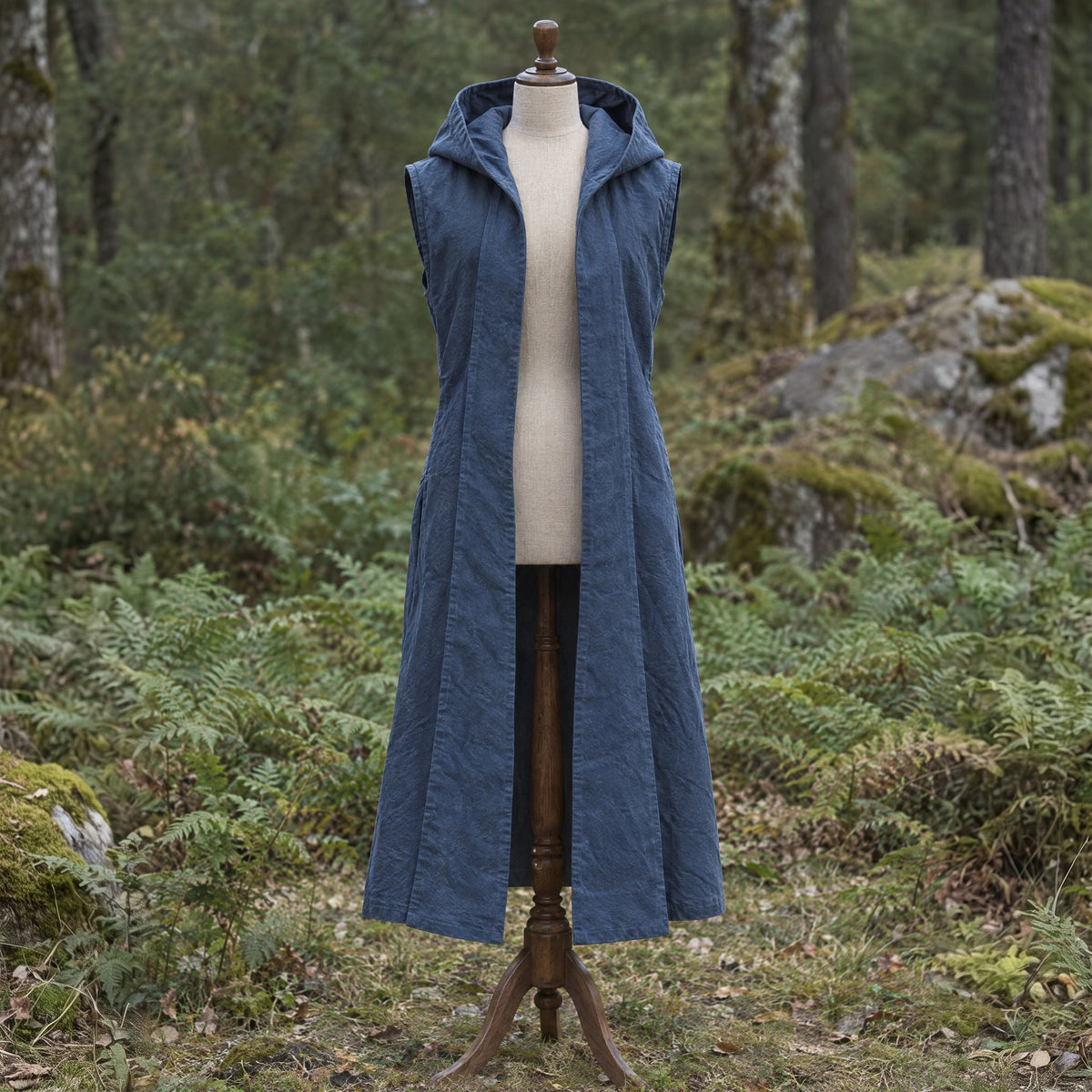 Grey sleeveless hooded overcoat on a dress form outdoors
