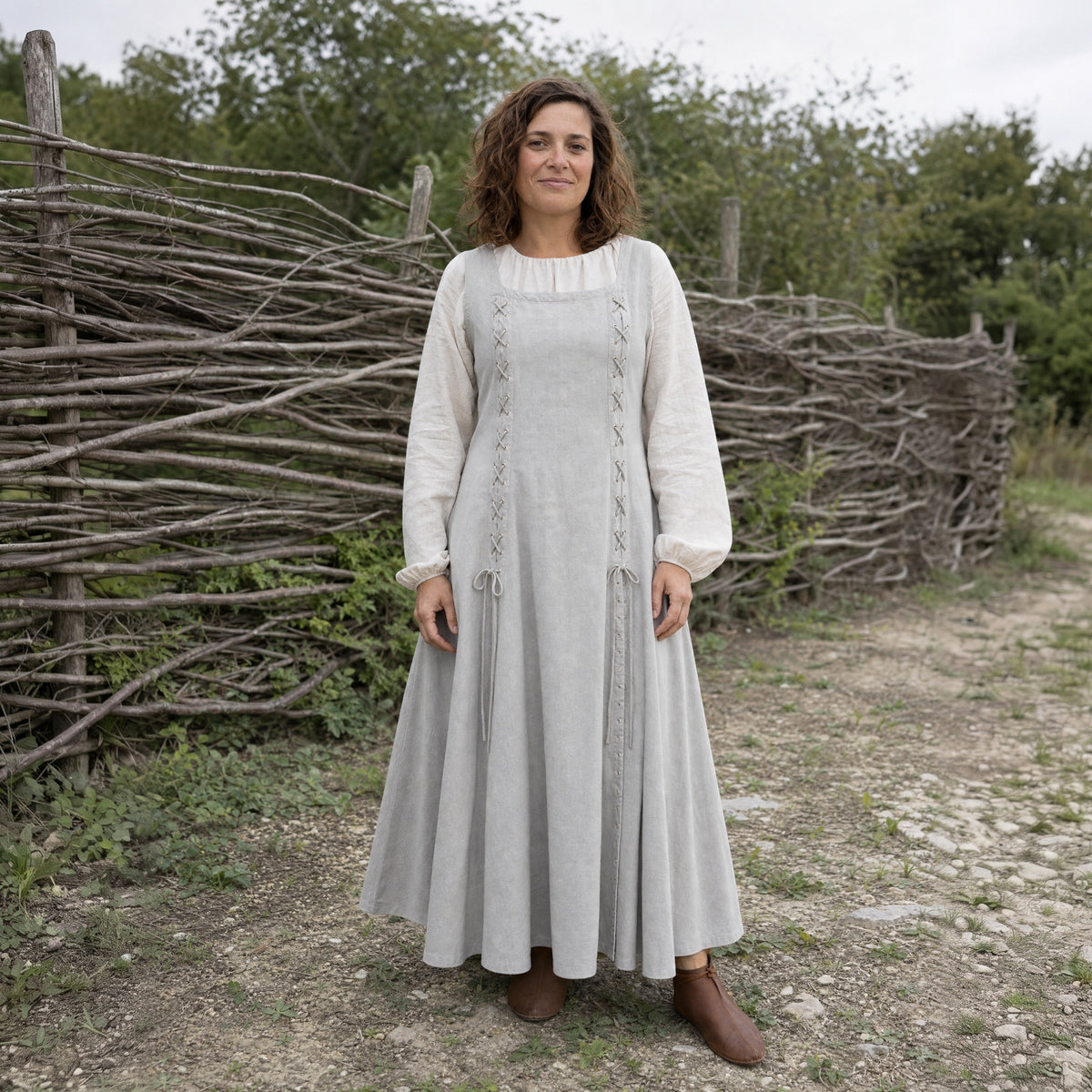Grey square-neck lace-up Renaissance dress worn by a woman outdoors, full-length front view