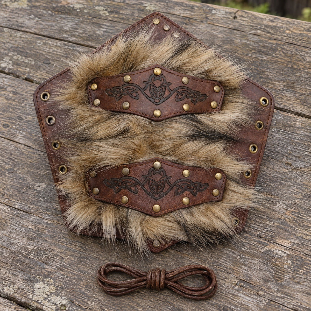 Brown studded bracer with fur-look trim on a rustic surface