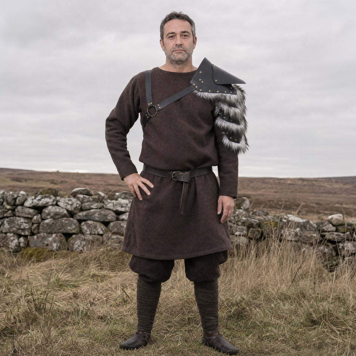 Black studded pauldron worn on one shoulder outdoors, full-length front view