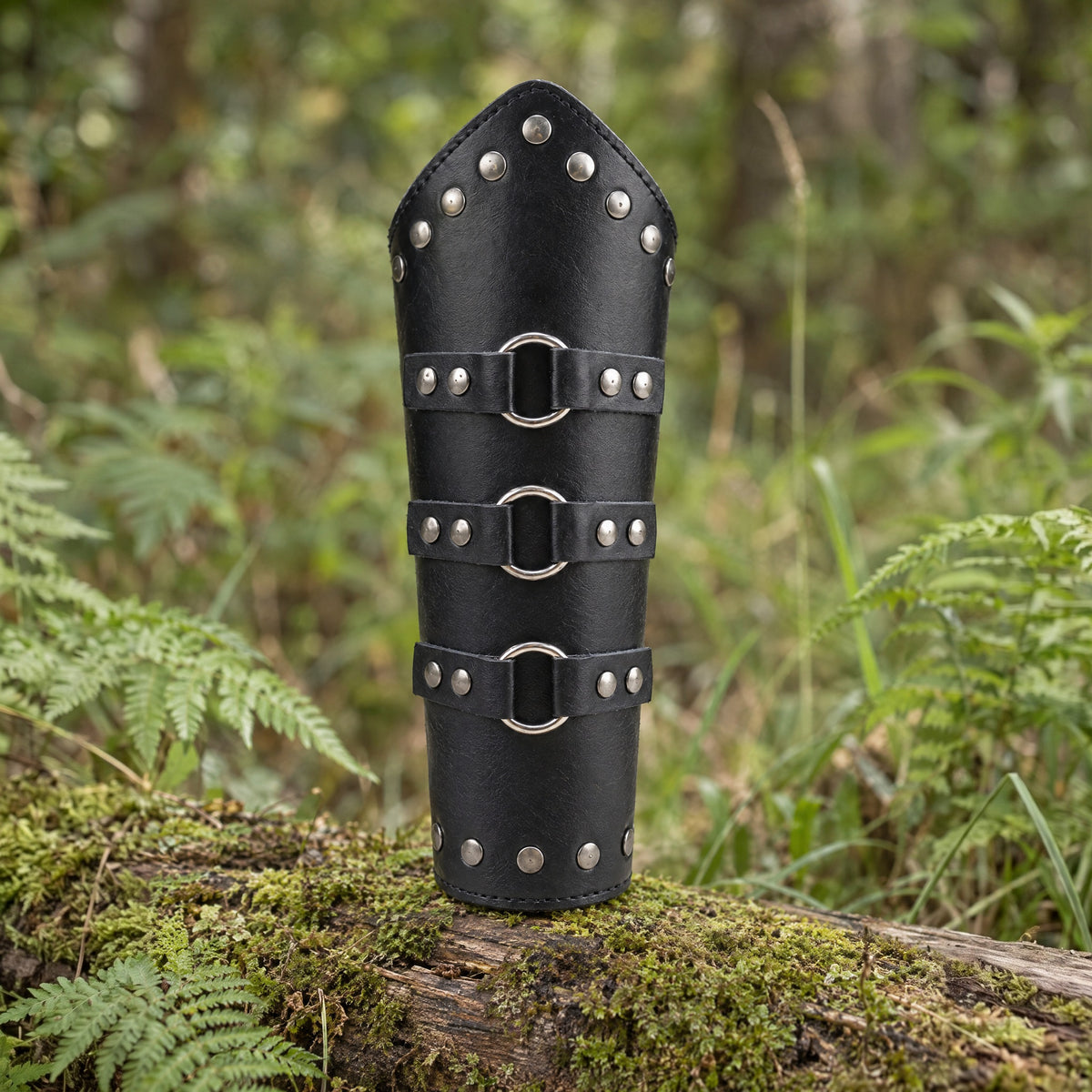 Black tall studded ring bracer on a rustic surface