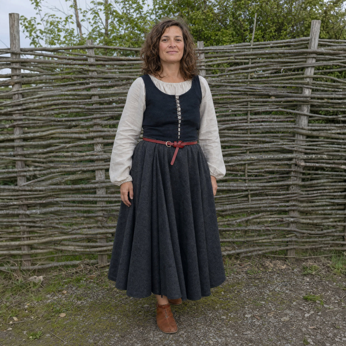 Red thin leather ring belt worn by a woman outdoors, full-length front view