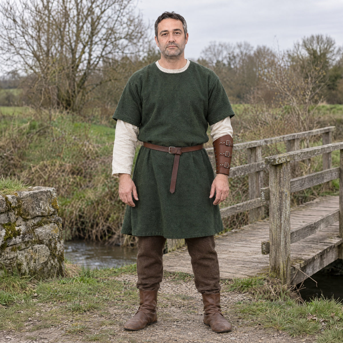 Brown three-buckle bracer worn on the forearm outdoors, full-length front view
