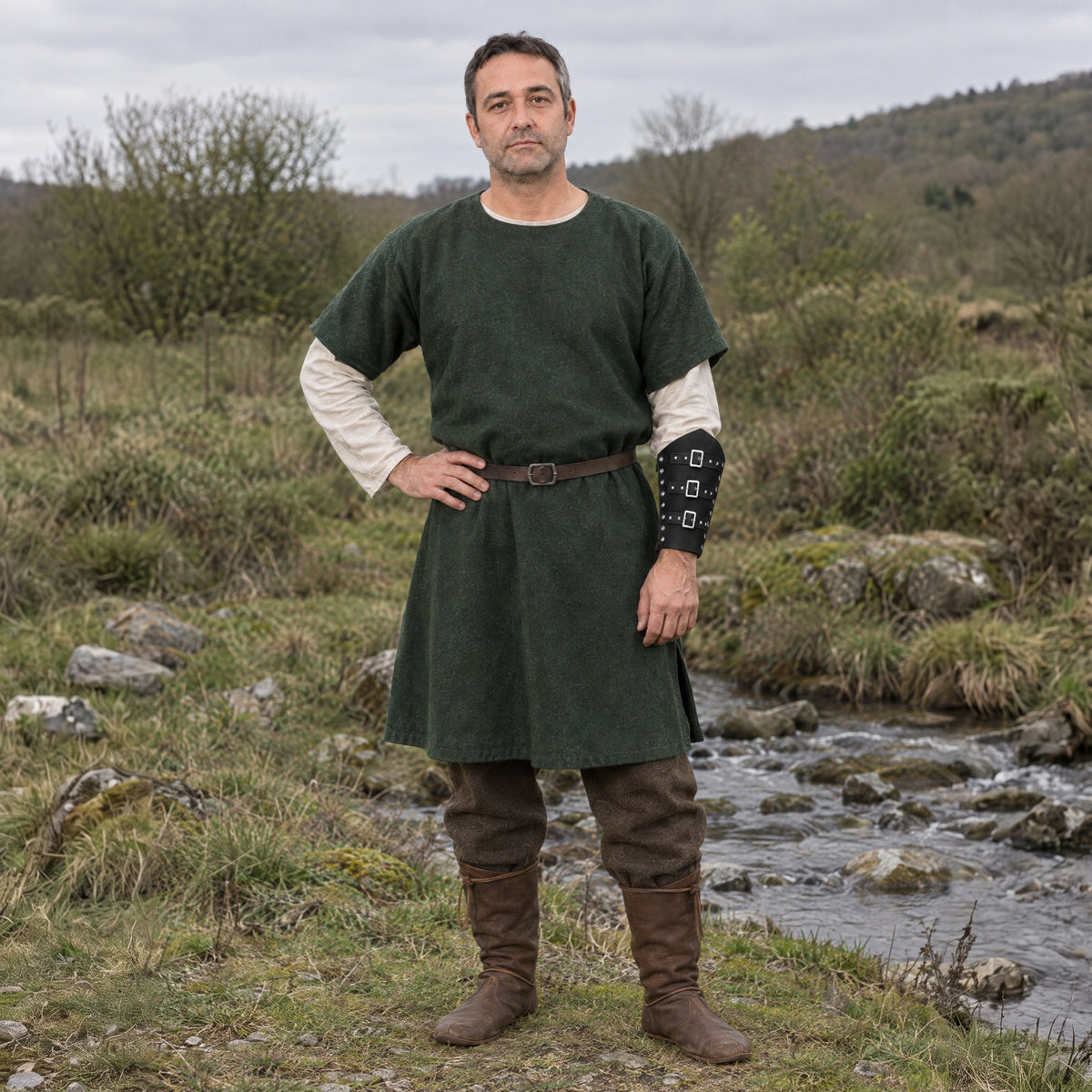 Black three-buckle bracer worn on the forearm outdoors, full-length front view