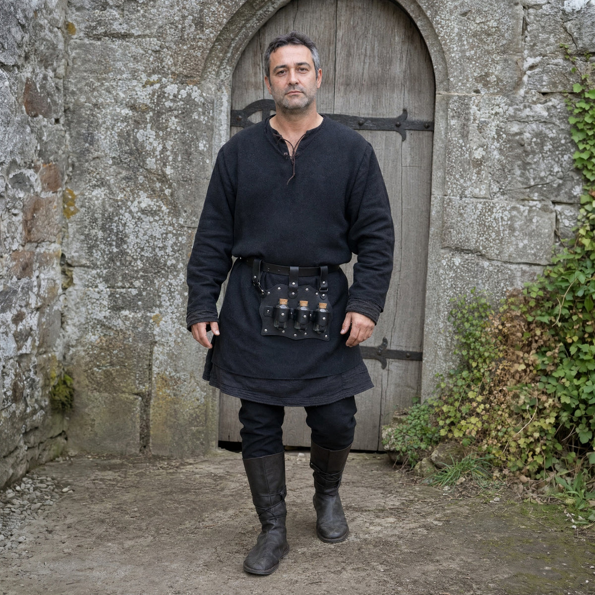 Black three-vial potion belt holder worn outdoors, full-length front view